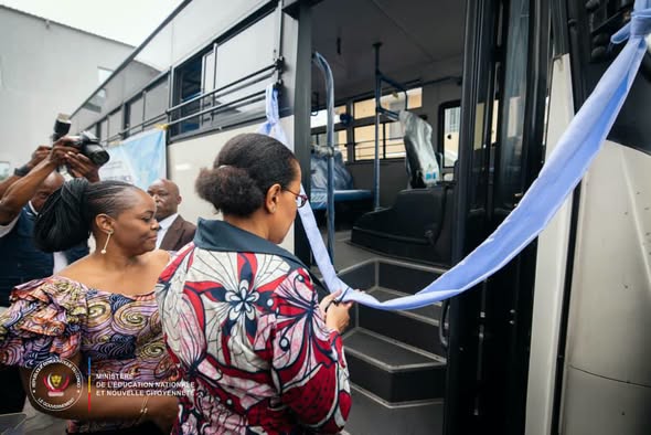 Hubert Kimbonza devant les deux bus remis à l’Inspection générale de l’Éducation nationale en RDC.